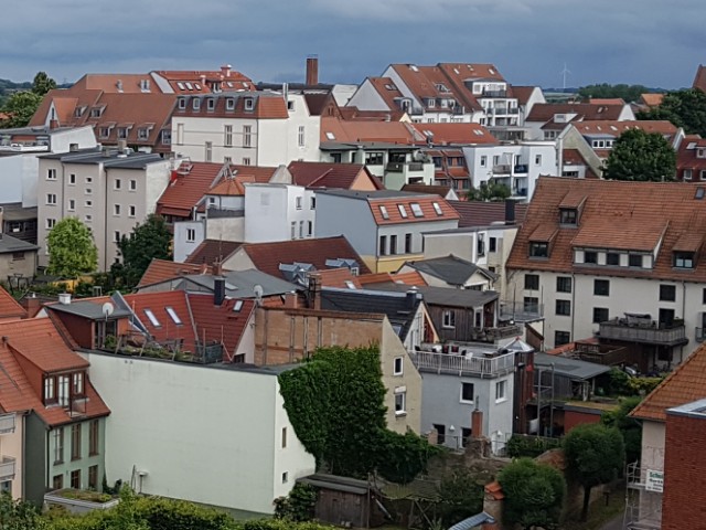 Das Foto zeigt von oben einige Häuser. Es handelt sich um die Ansicht einer Altstadt mit verwinkelten Gebäuden.