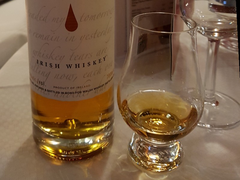 Das Foto zeigt eine Flasche Whiskey zusammen mit einem gefüllten Whiskyglas.