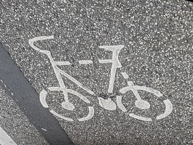 Das Foto zeigt die auf einem Fahrradweg angebrachte Markierung in Gestalt eines weiß stilisierten Fahrrades.